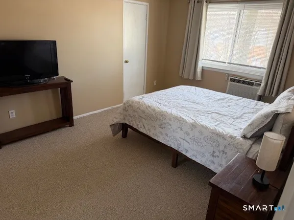 a bedroom with a bed and flat screen tv