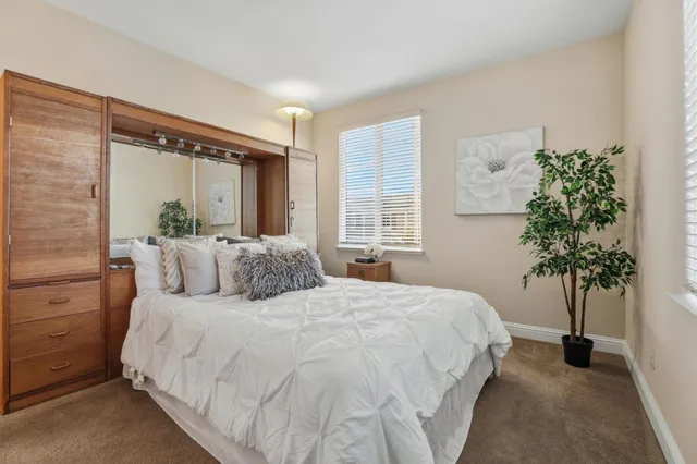 a bedroom with a large bed and a potted plant
