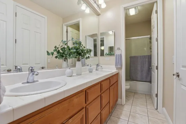 a bathroom with a granite countertop sink a toilet and a mirror