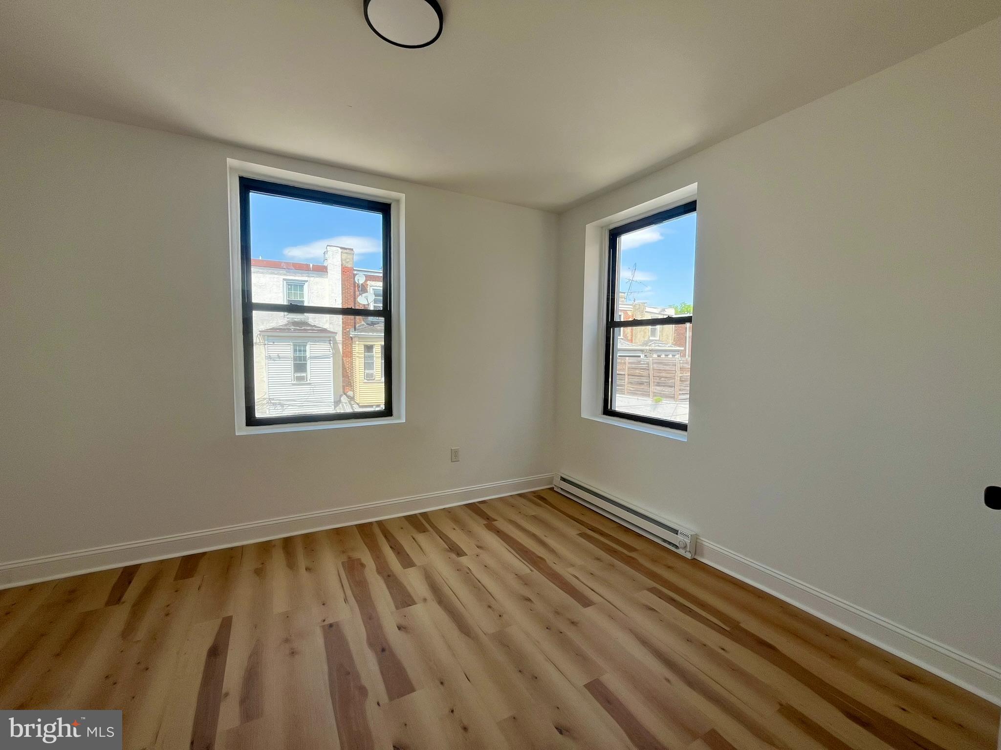 a view of a room with wooden floor and windows