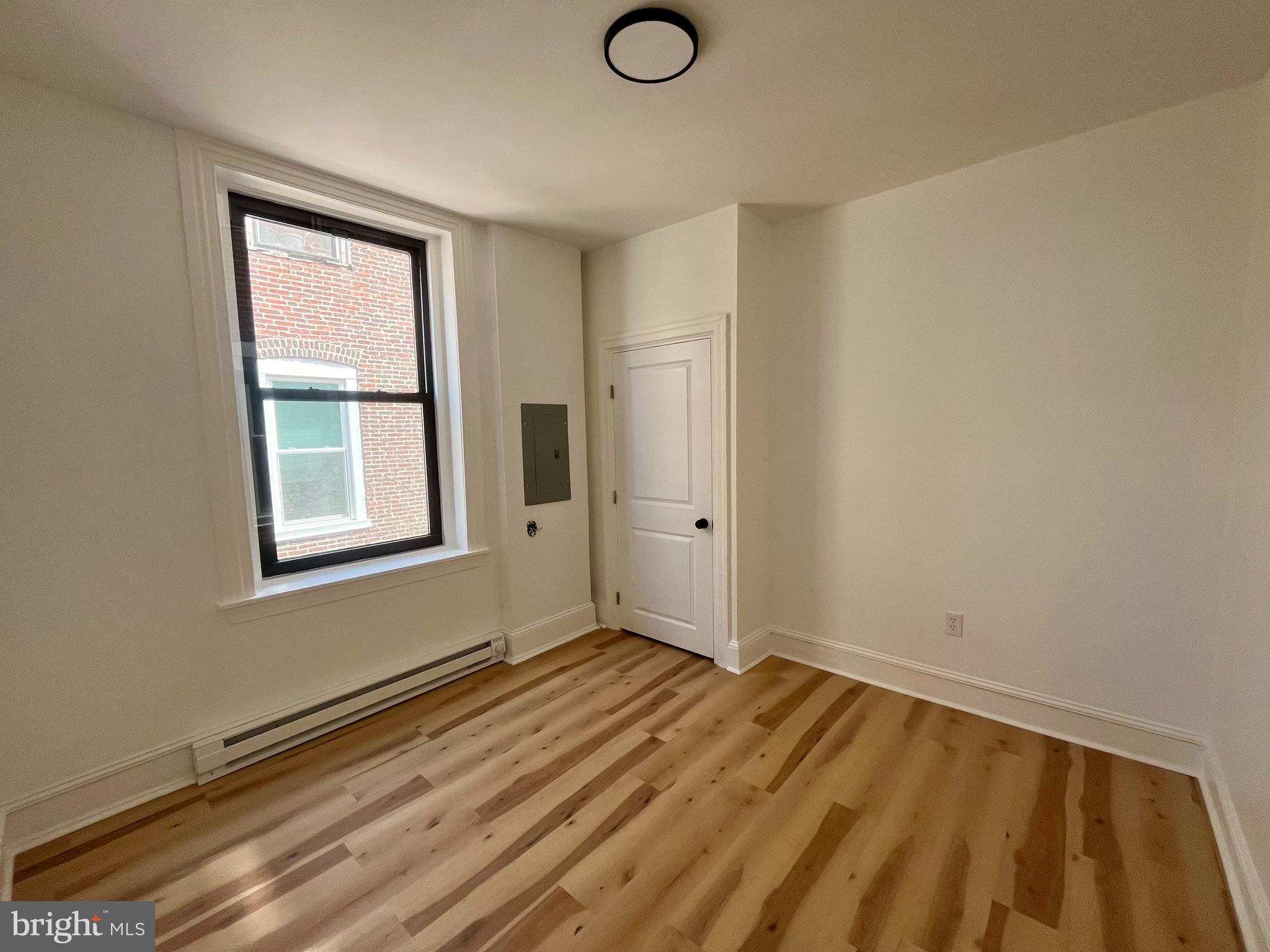 4413 Walnut Street, Unit 2R Philadelphia, PA 19104 - Photo 11 of 18 a view of an empty room with wooden floor and a window