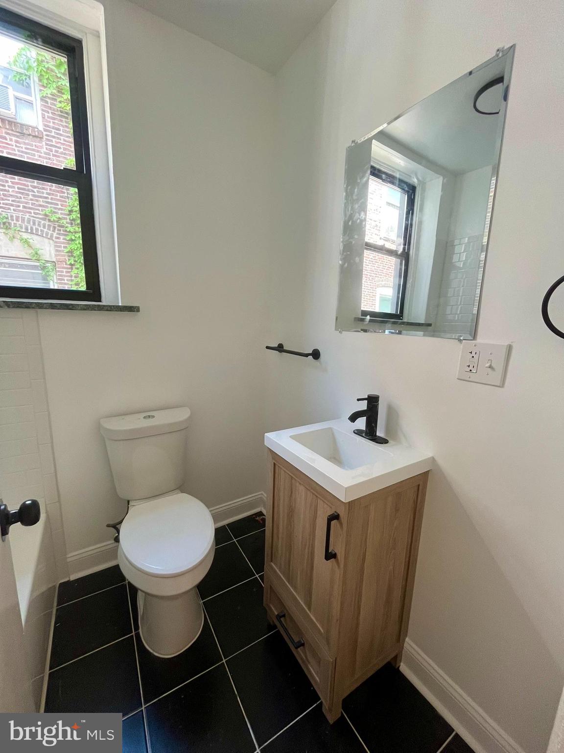 4413 Walnut Street, Unit 2R Philadelphia, PA 19104 - Photo 14 of 18 a bathroom with a toilet a sink a window and mirror