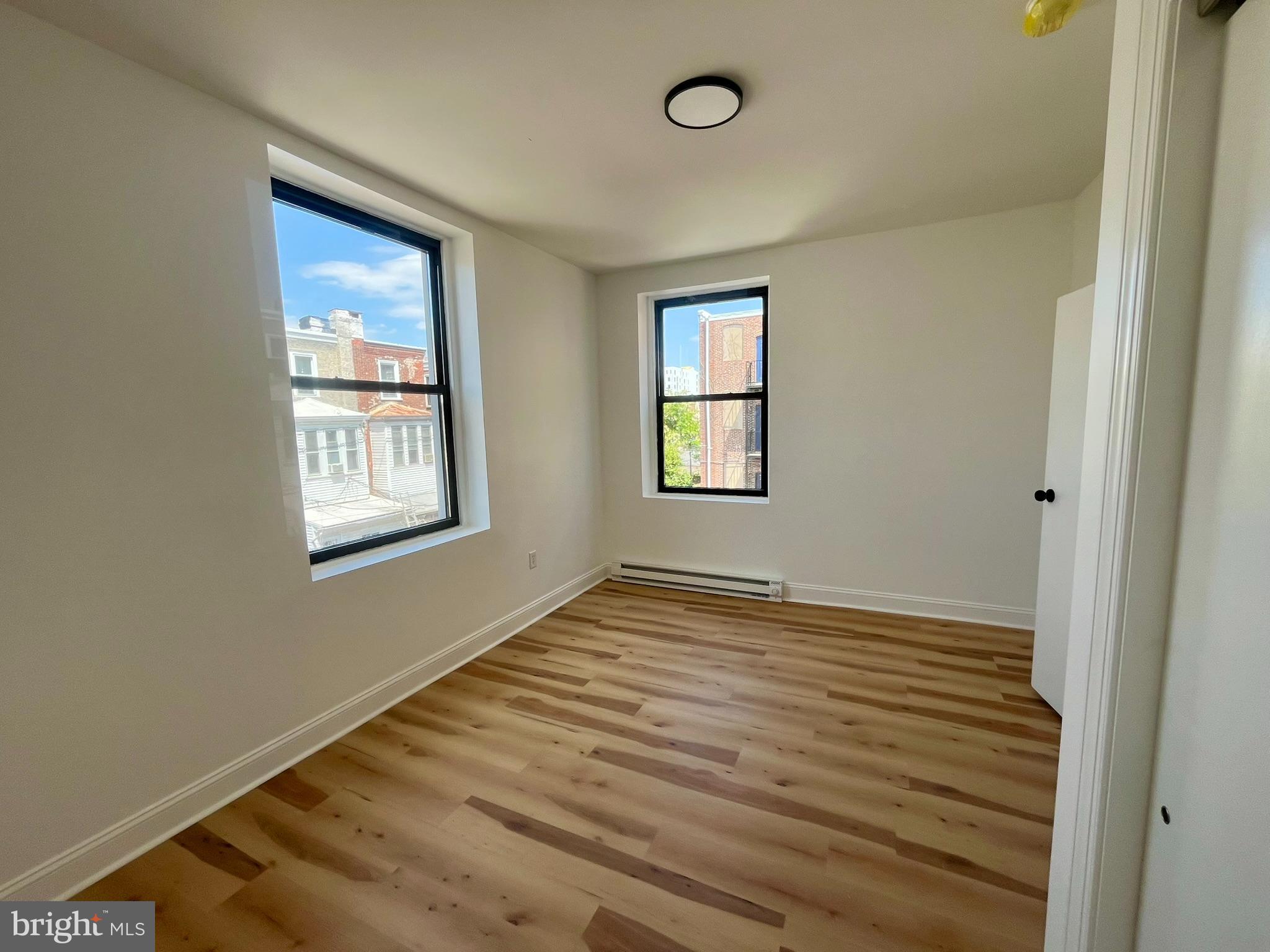 4413 Walnut Street, Unit 2R Philadelphia, PA 19104 - Photo 2 of 18 a view of an empty room with a window and wooden floor