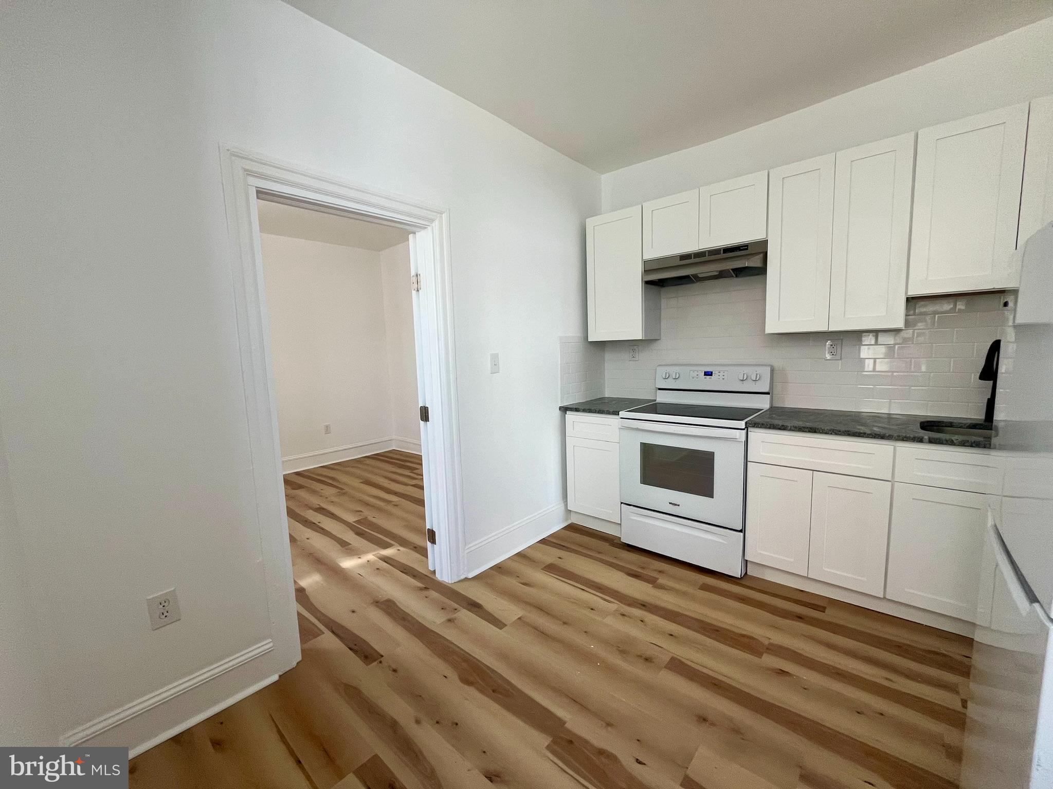 4413 Walnut Street, Unit 2R Philadelphia, PA 19104 - Photo 7 of 18 a kitchen with granite countertop white cabinets and white appliances