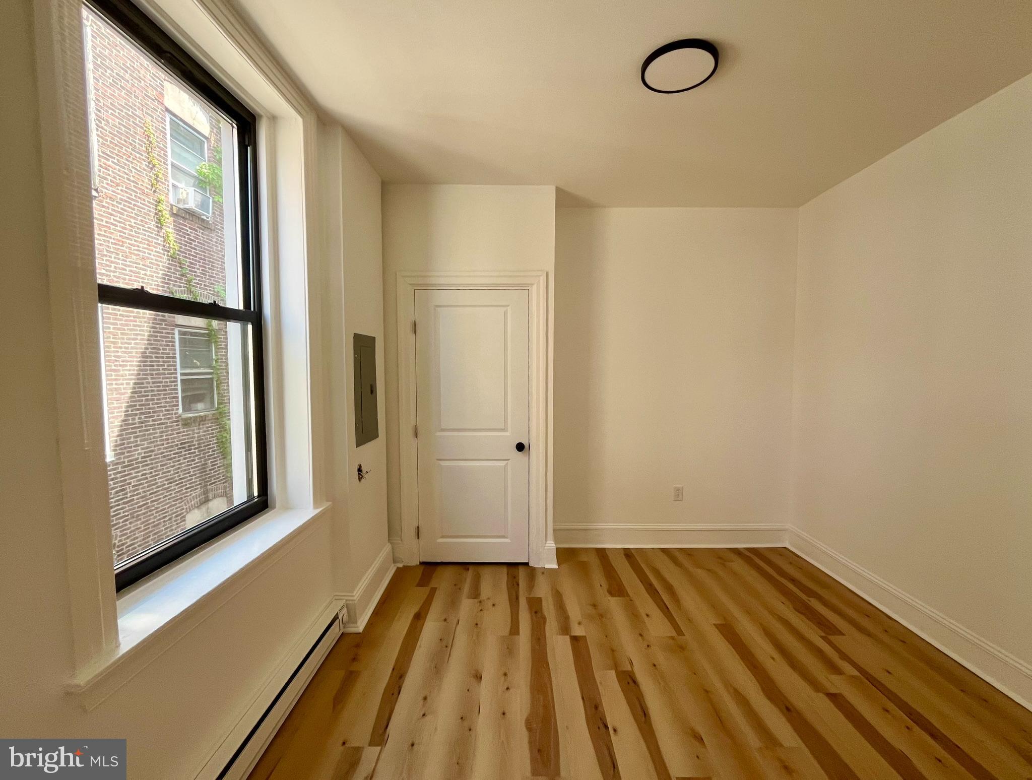 4413 Walnut Street, Unit 2R Philadelphia, PA 19104 - Photo 10 of 18 a view of a room with wooden floor and windows