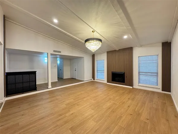 a view of an empty room with a fireplace and a window