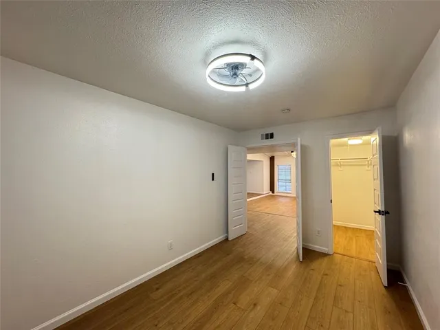 an empty room with wooden floor and window