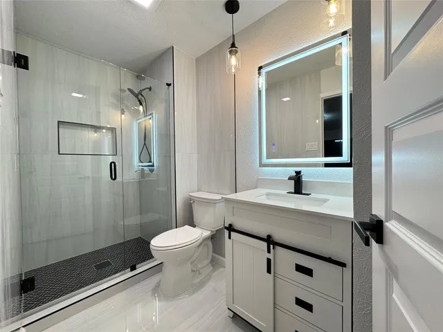 a bathroom with a sink a toilet and shower