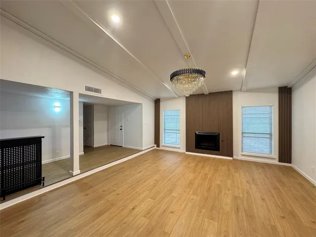 a view of an empty room with a fireplace and a window