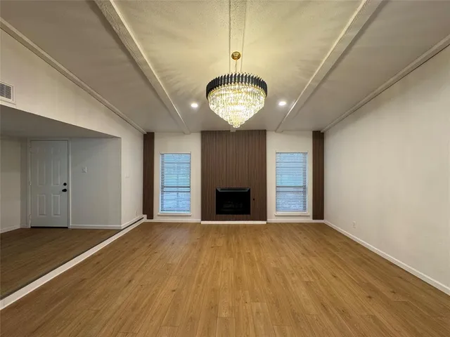 a view of an empty room with a fireplace and a window