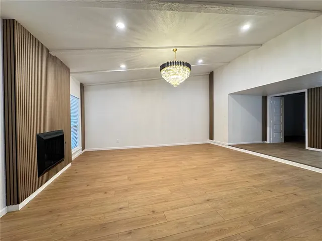 an empty room with wooden floor and fireplace