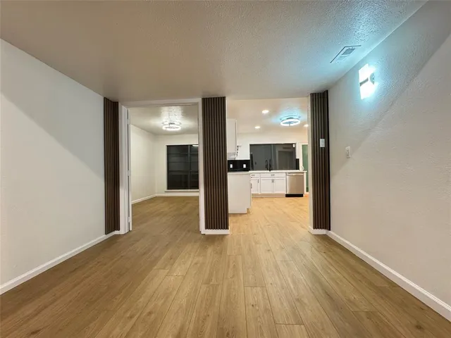 a view of a hallway with wooden floor and a large window