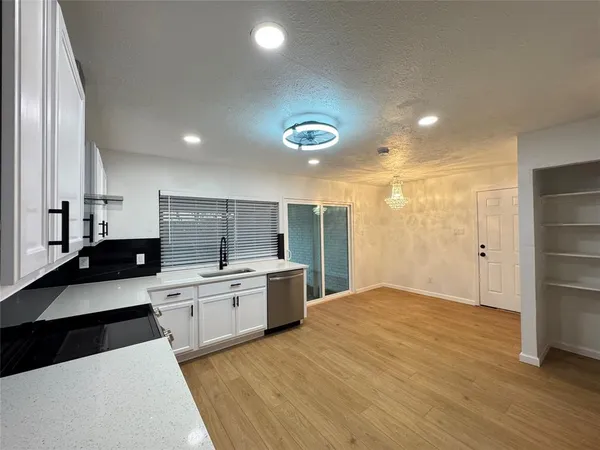 a large kitchen with a large counter top stainless steel appliances and cabinets