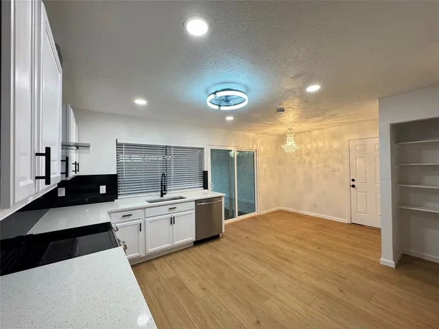 a large kitchen with a large counter top stainless steel appliances and cabinets