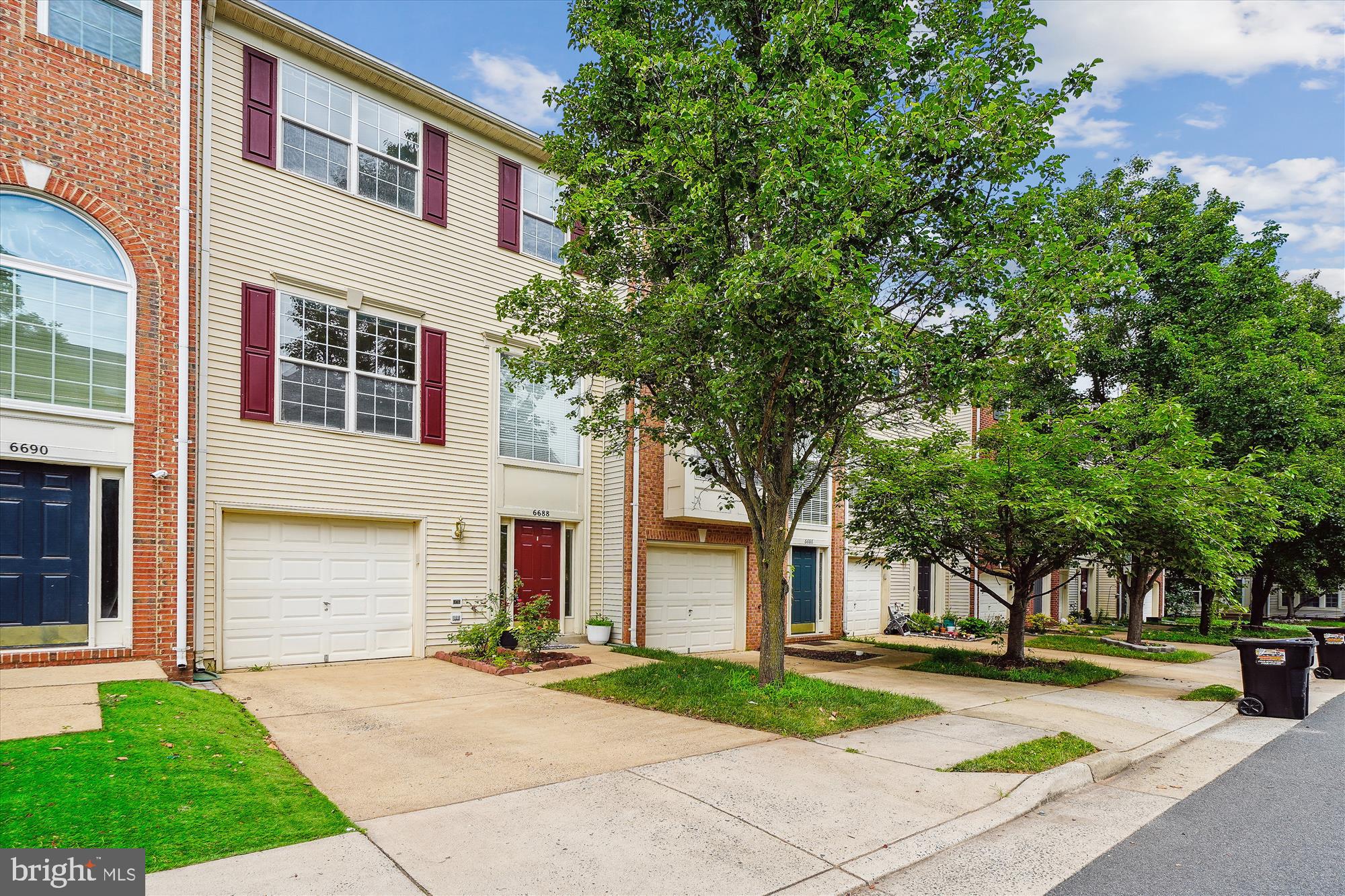 front view of a house with a yard and an trees