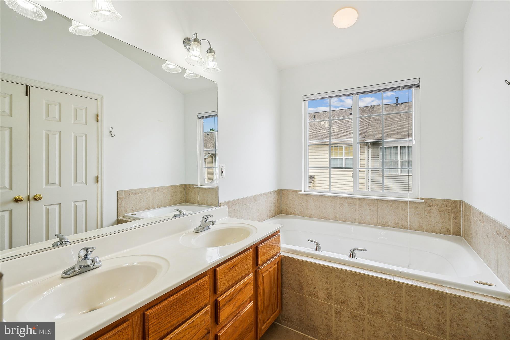 6688 Roderick Loop Gainesville, VA 20155 - Photo 22 of 40 a bathroom with a tub sink and mirror