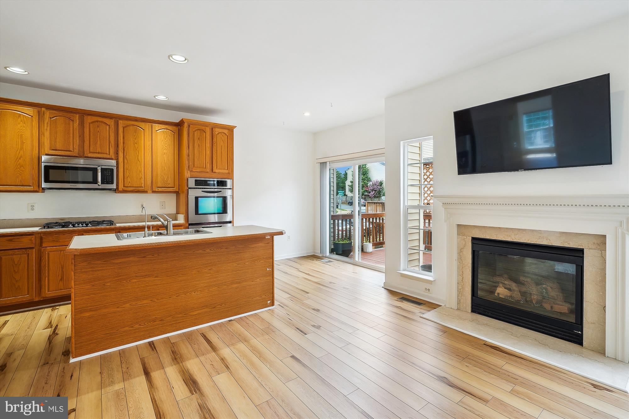 6688 Roderick Loop Gainesville, VA 20155 - Photo 10 of 40 a living room with stainless steel appliances furniture a fireplace and a flat screen tv