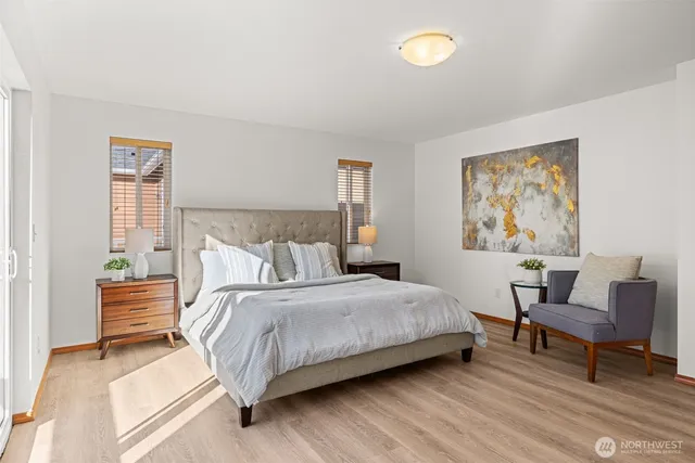 a bedroom with a bed and a lamp on dresser