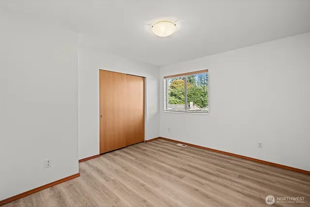an empty room with wooden floor and window