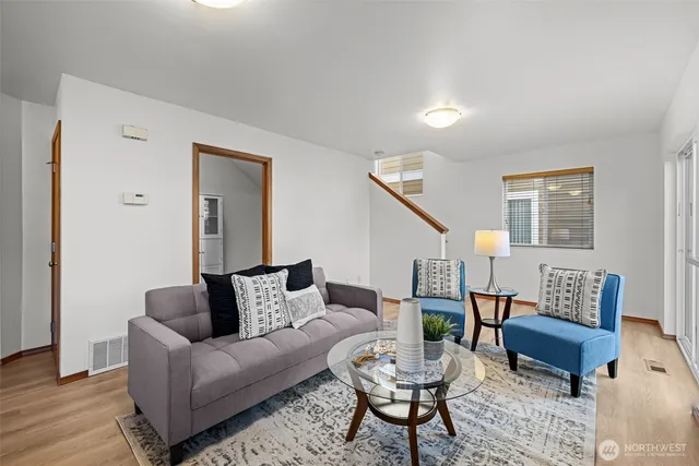 a living room with furniture and a wooden floor