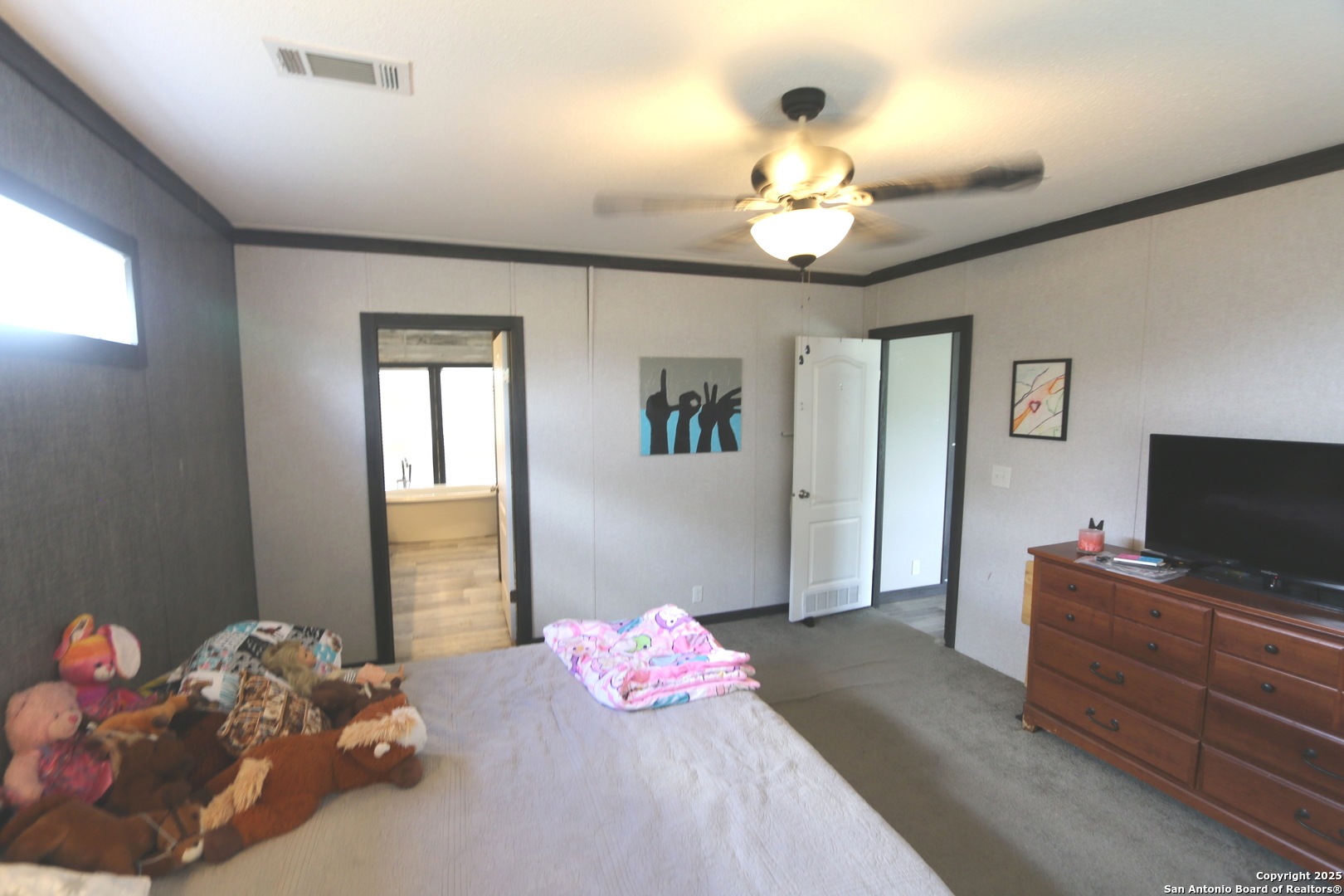 7510 Pittman Road Adkins, TX 78101 - Photo 24 of 42 a bedroom with a bed and flat screen tv