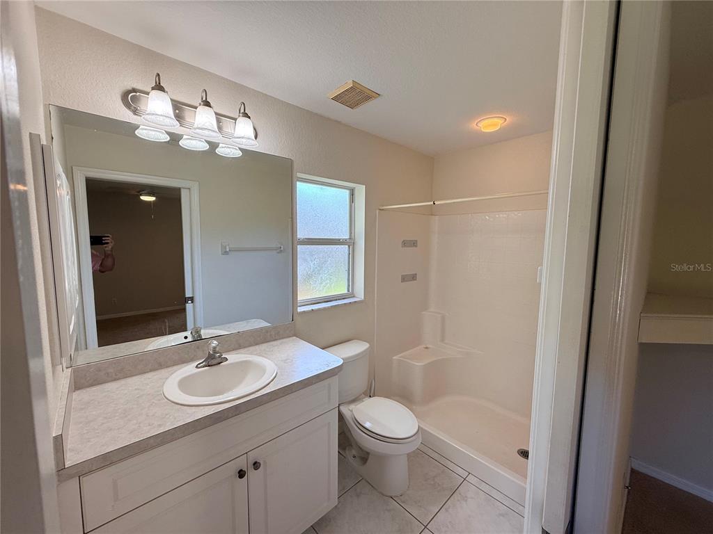 4185 Amari Road North Port, FL 34291 - Photo 9 of 14 a bathroom with a granite countertop sink a toilet and a mirror