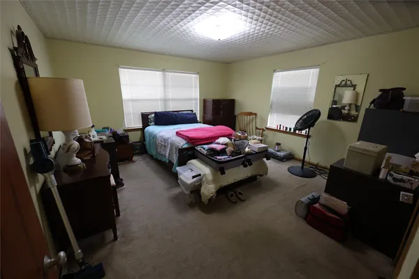 a view of an empty room with a window and a dresser