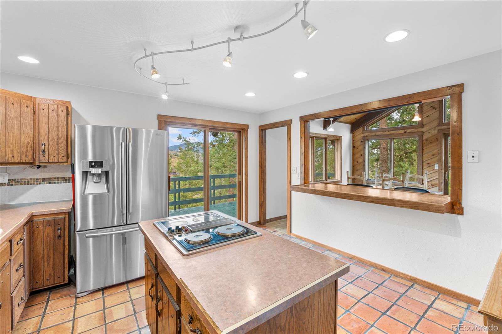 730 Clear Creek Road Evergreen, CO 80439 - Photo 11 of 44 a kitchen with a refrigerator a stove top oven and a large window