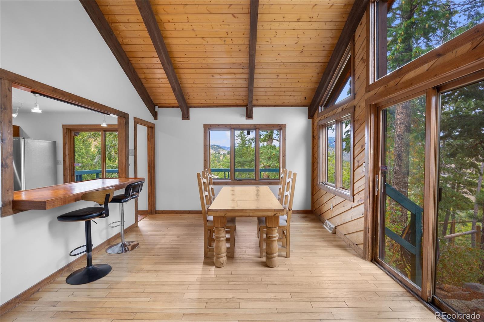 730 Clear Creek Road Evergreen, CO 80439 - Photo 17 of 44 a dining room with wooden floor and outdoor seating