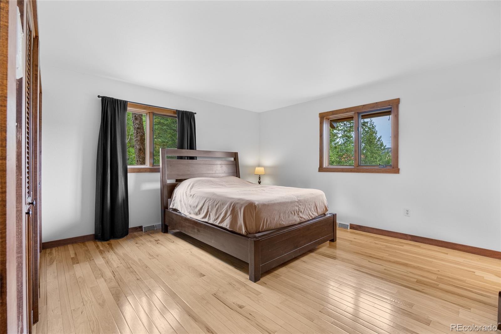 730 Clear Creek Road Evergreen, CO 80439 - Photo 19 of 44 a spacious bedroom with a bed and a window