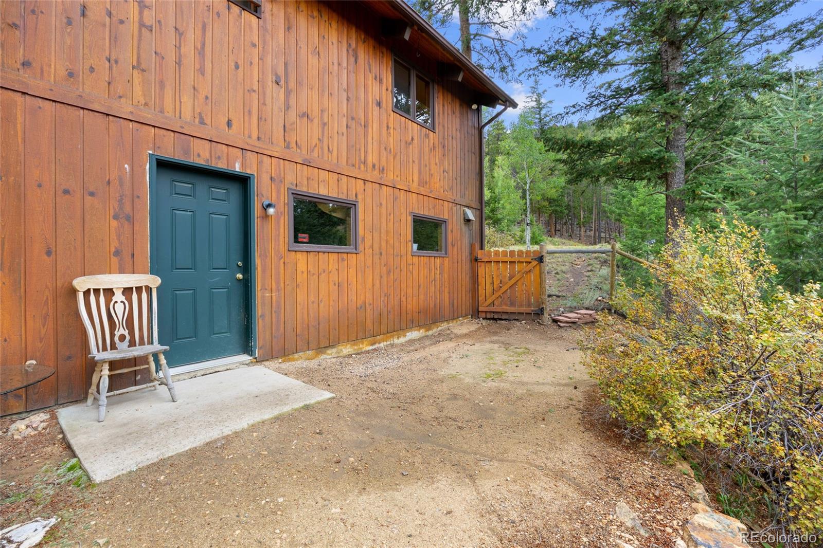 730 Clear Creek Road Evergreen, CO 80439 - Photo 38 of 44 a backyard of a house with table and chairs