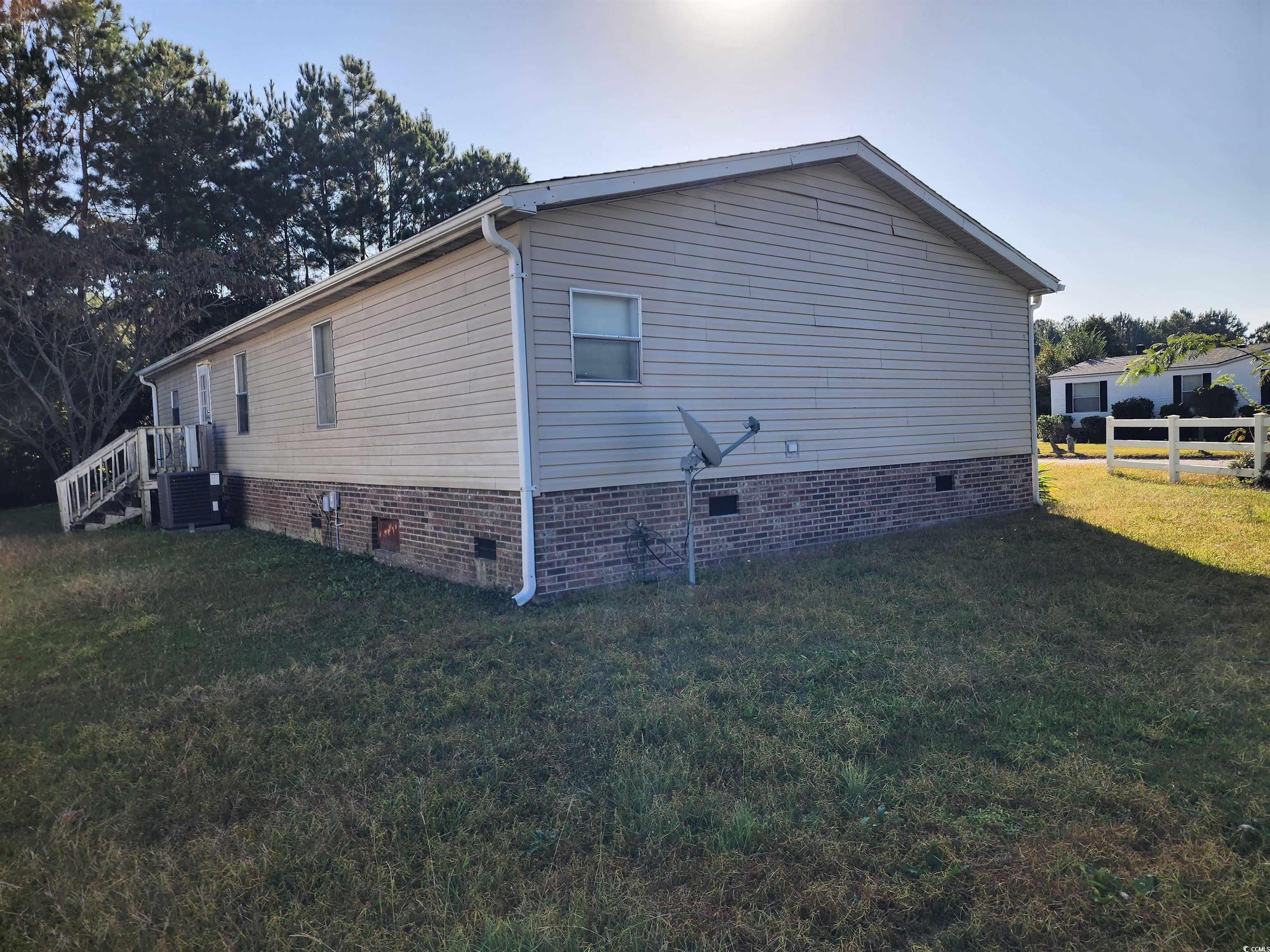 5160 Spring Street Loris, SC 29569 - Photo 4 of 18 View of side of home with cooling unit and a yard