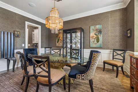 a view of a dining room with furniture a chandelier and wooden floor