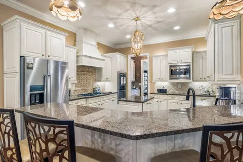 a kitchen with stainless steel appliances granite countertop a sink a stove and refrigerator