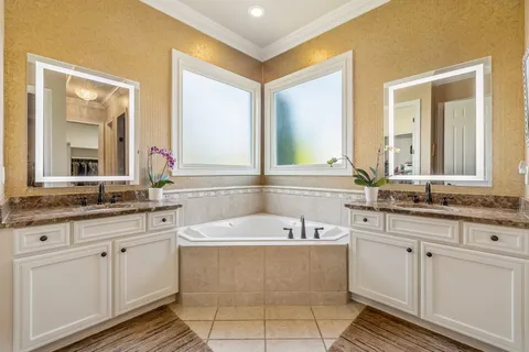 a bathroom with a tub sink and mirror