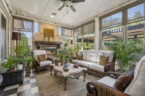 a living room with patio furniture and a potted plant