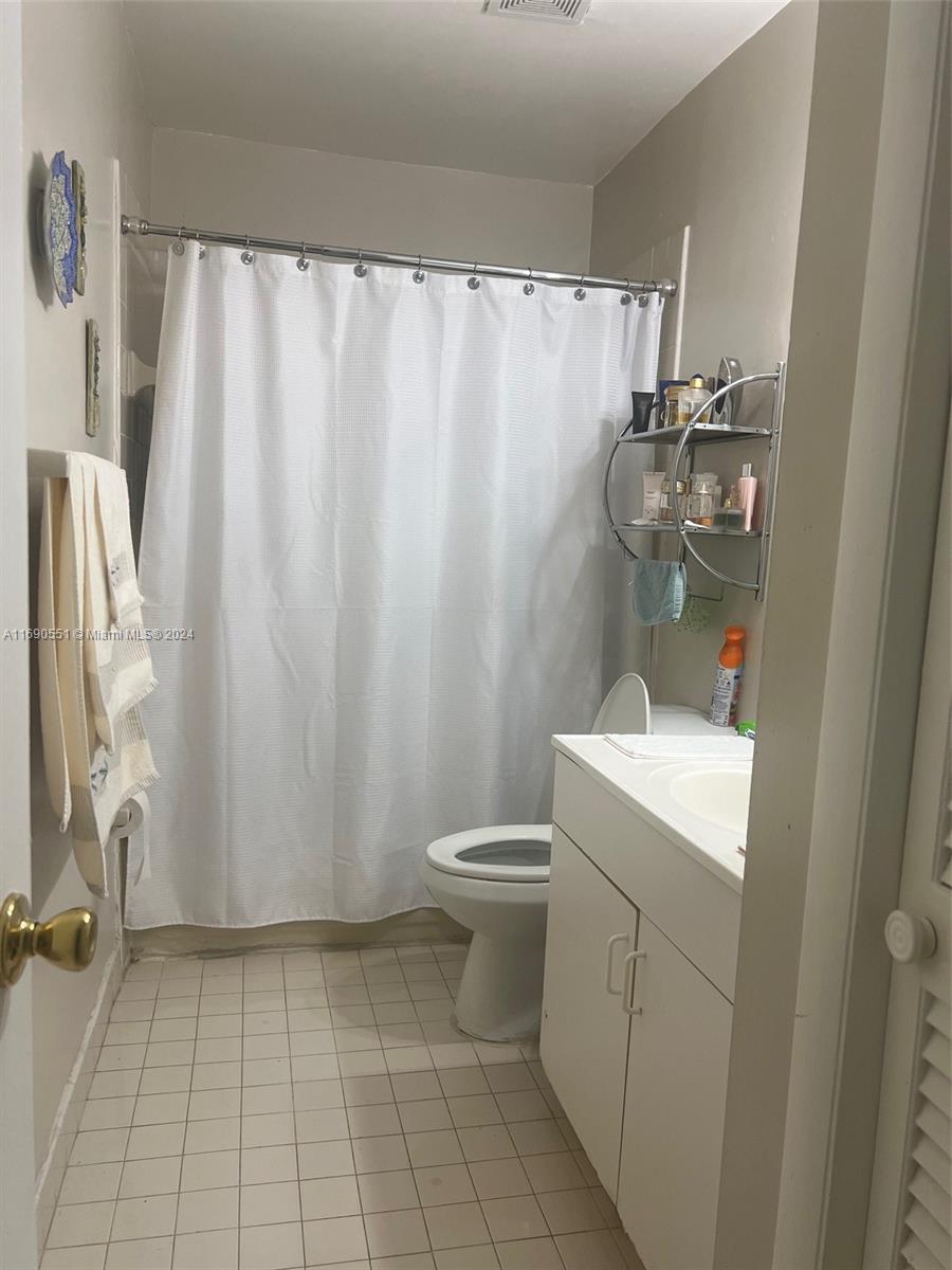 16331 Southwest 104th Avenue Miami, FL 33157 - Photo 13 of 23 a bathroom with a sink a toilet and shower curtain