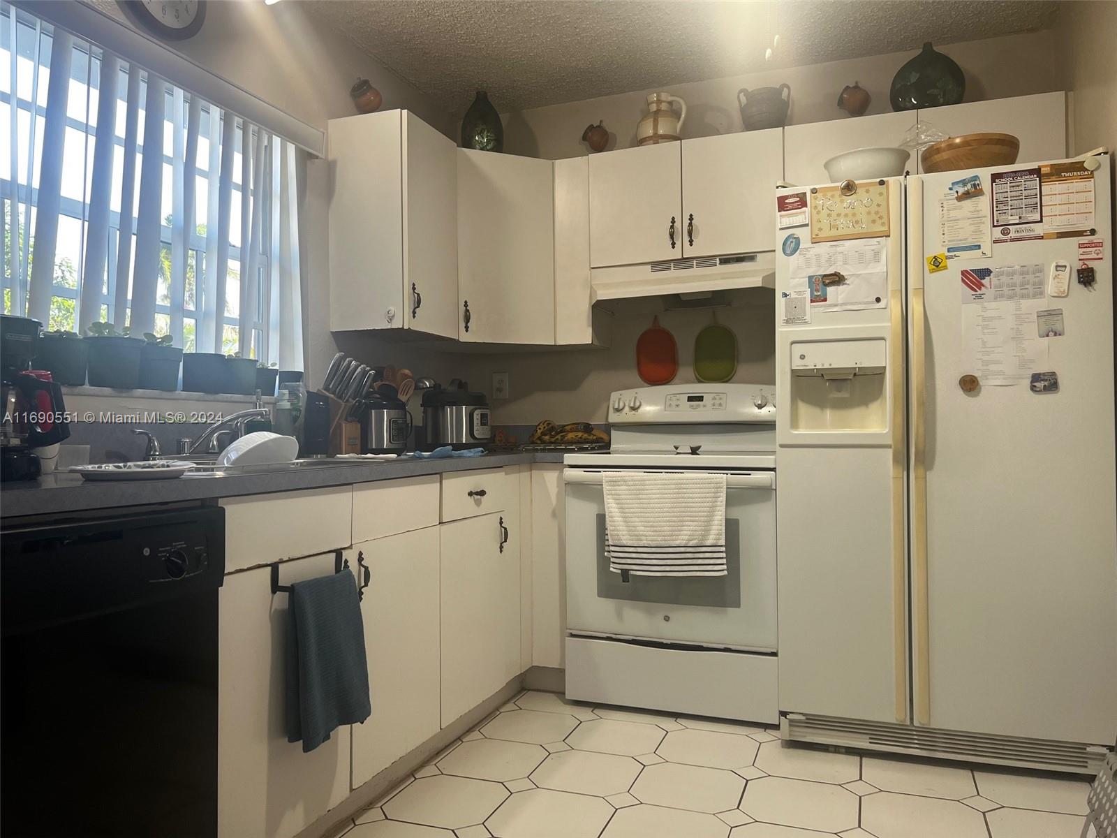 16331 Southwest 104th Avenue Miami, FL 33157 - Photo 17 of 23 a kitchen with white cabinets and white appliances