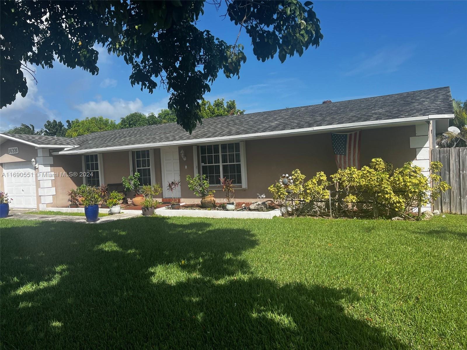 16331 Southwest 104th Avenue Miami, FL 33157 - Photo 2 of 23 a front view of house with yard and green space