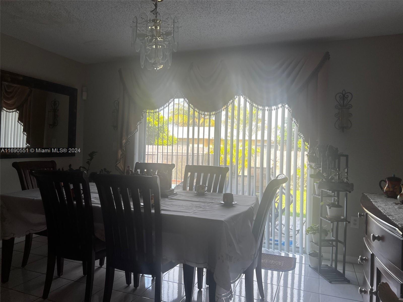 16331 Southwest 104th Avenue Miami, FL 33157 - Photo 7 of 23 a view of a dining room with furniture and chandelier