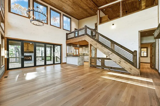 a view of an empty room with wooden floor and a fireplace