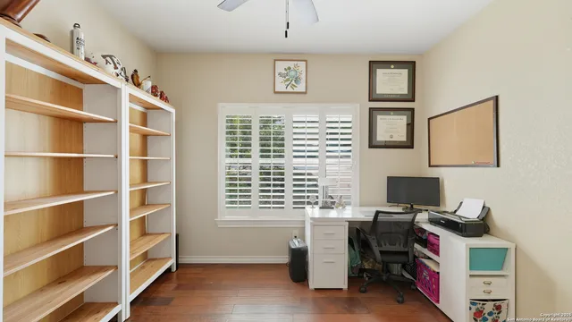 a view of a workspace with furniture and a window