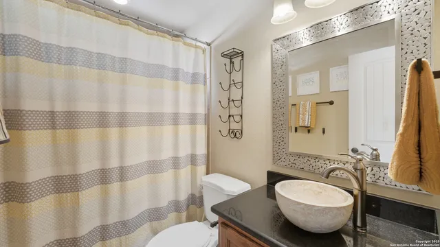 a bathroom with a granite countertop sink and a mirror