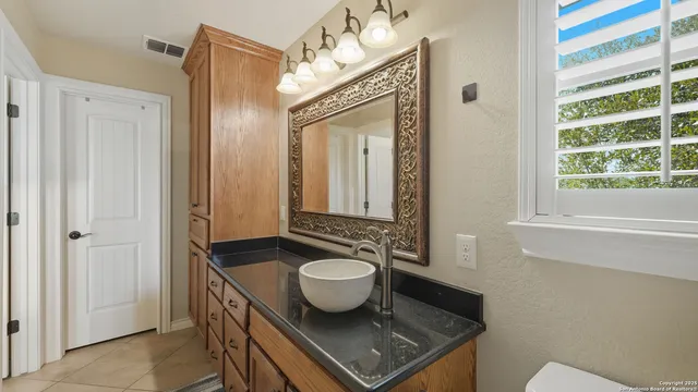 a bathroom with a granite countertop sink a mirror and a shower