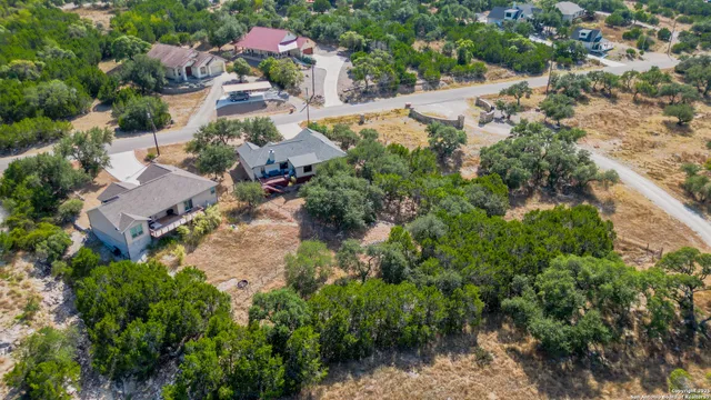 an aerial view of residential house with outdoor space and trees all around