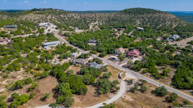 an aerial view of a residential houses with city and green space