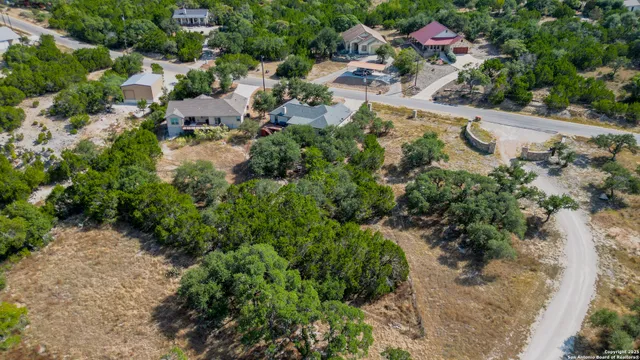 an aerial view of residential house with outdoor space and trees all around