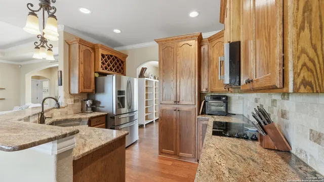a kitchen with stainless steel appliances granite countertop a sink a stove and a refrigerator