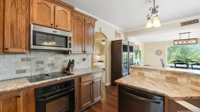 a kitchen with stainless steel appliances granite countertop a stove microwave refrigerator and sink