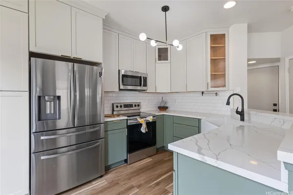 a kitchen with kitchen island stainless steel appliances a sink cabinets and wooden floor